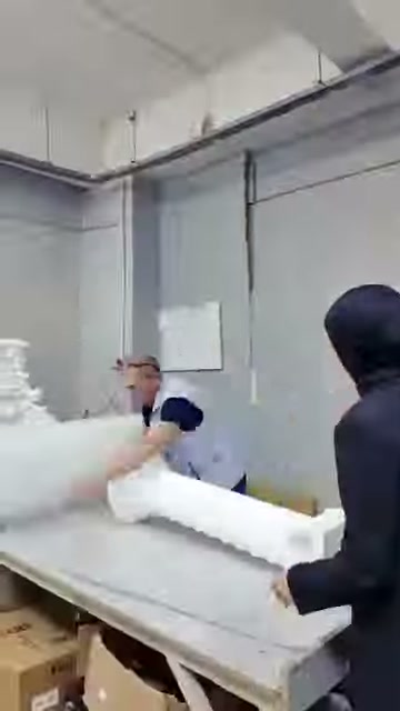 Sunucu ve çalışan, uzun parçayı paketleme tezgâhında hazırlıyor.