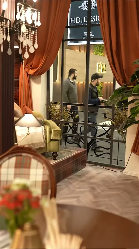 Kemerli balkon geçidinde turuncu perdeler ve siyah korkuluklar görülüyor