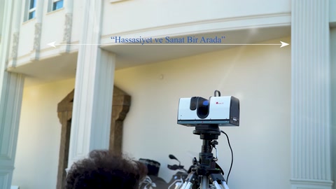 Tripodlu tarayıcı, sütunlar ve üst cephe ayrıntıları önünde çalışıyor.