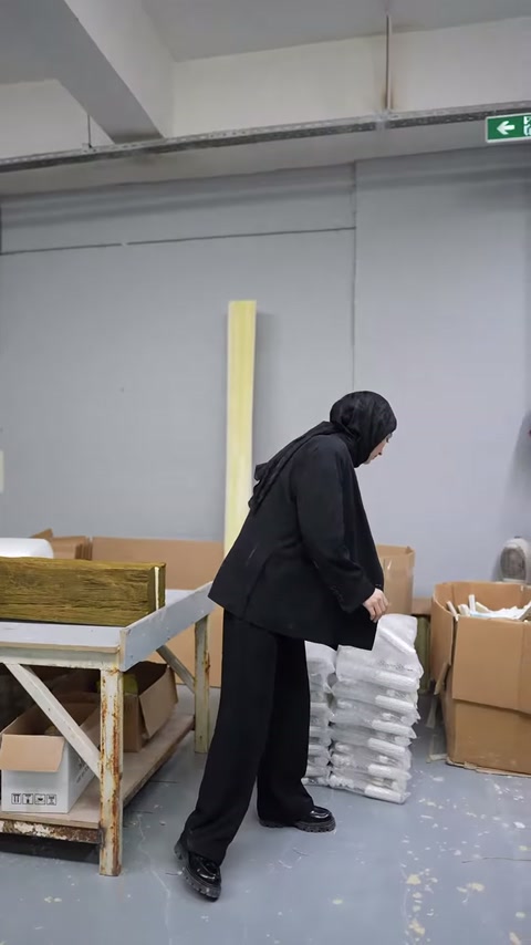 Sunucu, paketleme öncesi bekleyen küçük kabartmalı ürünlere uzanıyor.