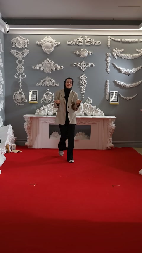 Sunucu, duvar bezemeleri önünde dekoratif sütunları tanıtmaya hazırlanıyor.