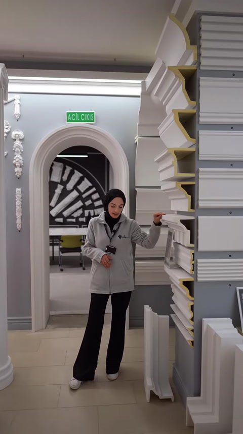 Sunucu farklı kesitlere sahip söve modellerini rafta gösteriyor