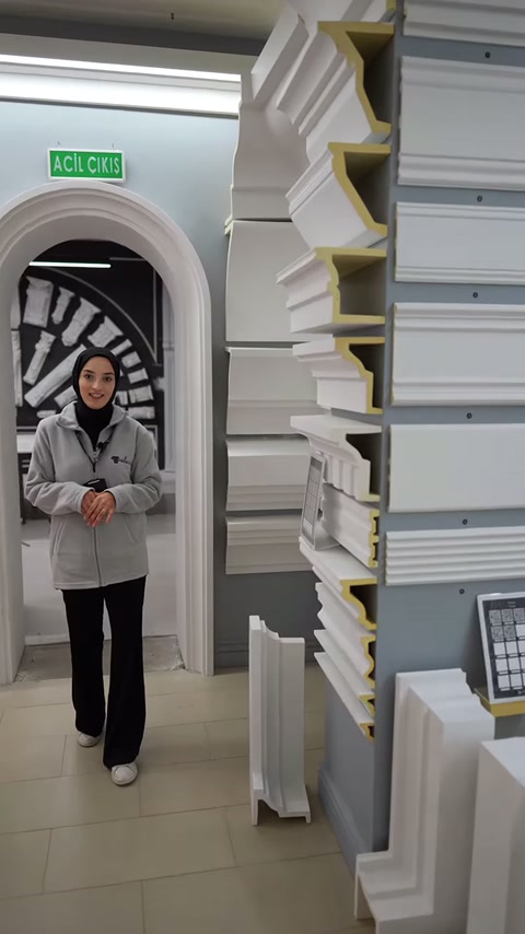 Sunucu profillerle kaplı duvarın önünde ürün seçeneklerini açıklıyor.