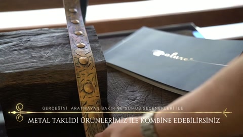 Metal süsleme bandı, kiriş yüzeyinde elle sabit konumda tutuluyor.