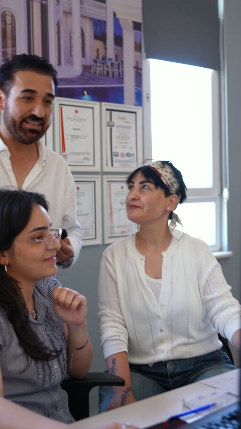 İki tasarımcı ve uzman, ofiste proje ayrıntılarını birlikte konuşuyor.