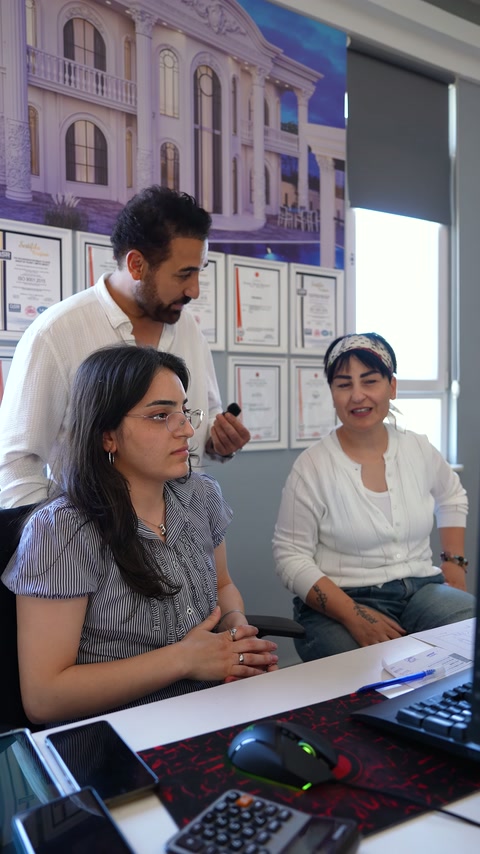 Tasarımcı, ofis masasında dekorasyon tercihlerini ekibe açıklıyor.