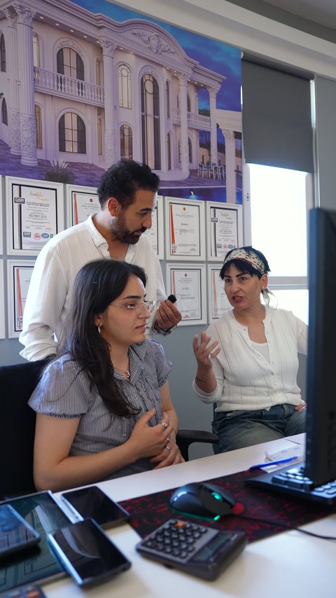 Masa başındaki ekip, bilgisayar yanında uygulama seçeneklerini konuşuyor.