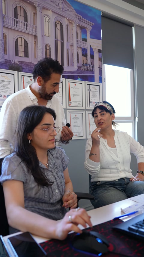 Bilgisayar kullanan ekip üyesi, tasarımcının ürün yorumlarını dinliyor.