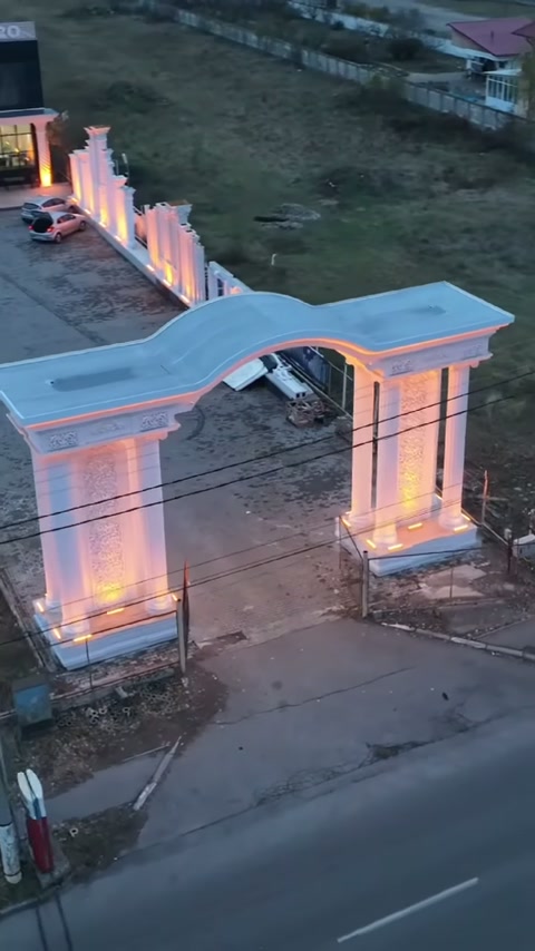 Yol cephesindeki kemerli giriş, çift kolon gruplarıyla akşam ışığında öne çıkıyor