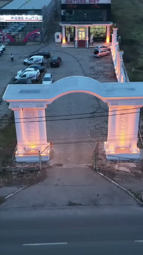 Dalgalı kemer formu, süslemeli dikmeler üzerinde yol girişini çevreliyor