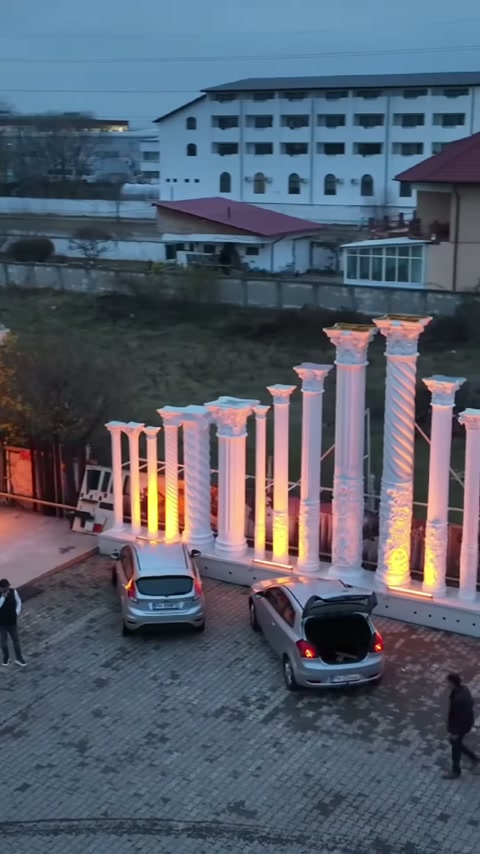 Aydınlatmalı kolon sırası, bina girişinden yol tarafına doğru devam ediyor