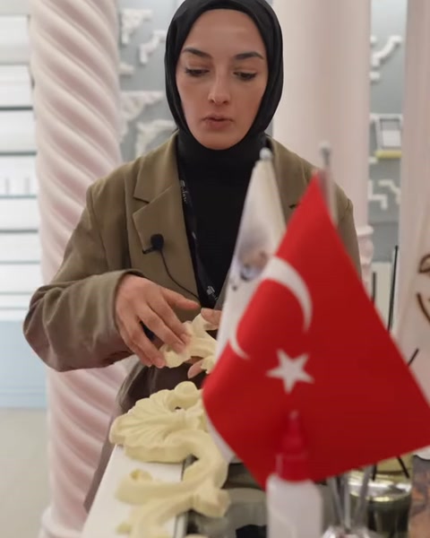 Açık sarı kıvrımlı motif, esnekliği göstermek için elle bükülüyor