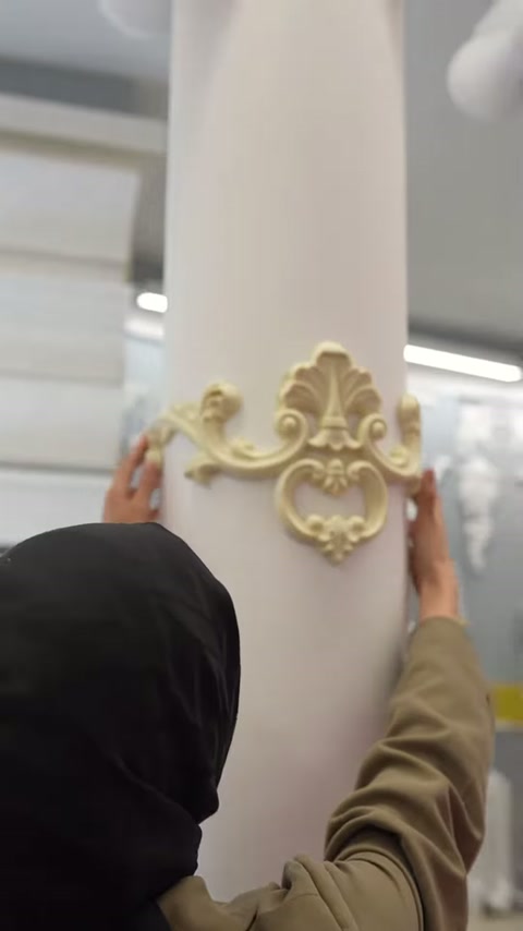 Yerleştirilen klasik motif sütun yüzeyinde iki elle kontrol ediliyor