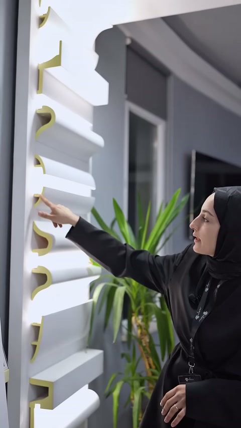Sunucu, sergide bulunan çıkıntılı poliüretan kartonpiyer modeline yöneliyor.