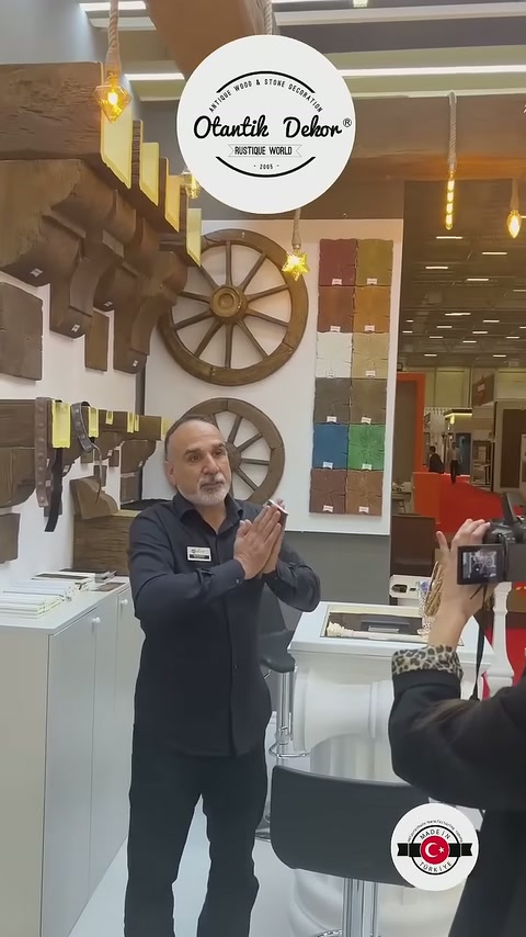 Kiriş numuneleriyle çevrili stantta görevli ziyaretçilere ürün sunumu yapıyor