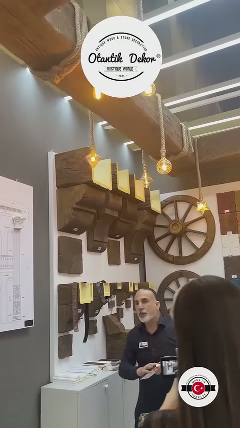 Sarkıt ampullerle aydınlatılan kiriş uygulaması sunum alanının üzerinde uzanıyor