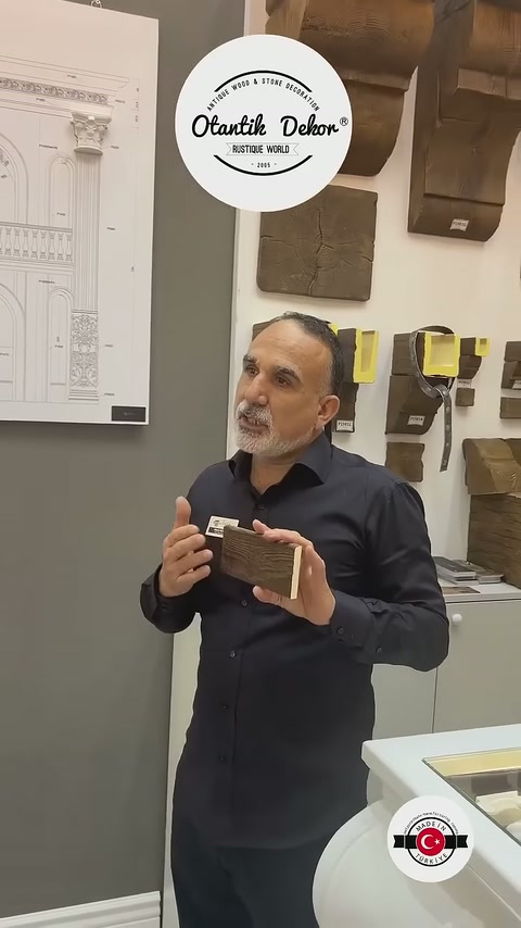 Görevli dekoratif kiriş numunesini iki eliyle tutarak ayrıntılarını tanıtıyor
