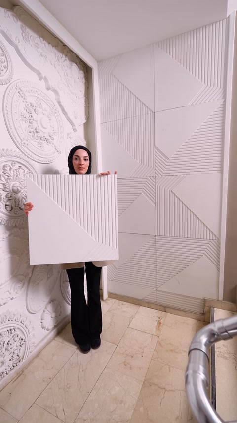 Kare poliüretan panel, geometrik desenli duvar uygulaması önünde tanıtılıyor