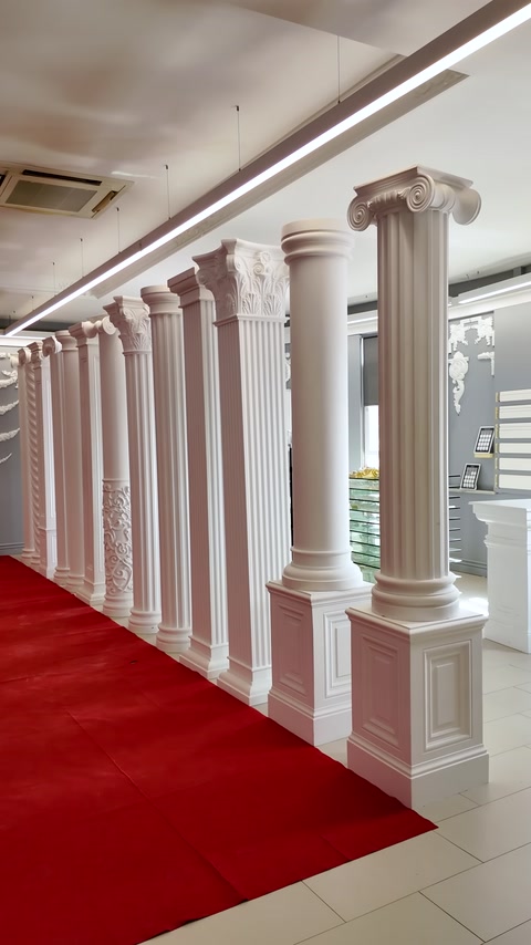 Showroom boyunca sıralanan farklı gövde ve başlıklardaki dekoratif sütunlar