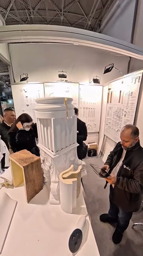 Dekoratif sütun maketi önünde ürünler hakkında bilgi paylaşımı yapılıyor.