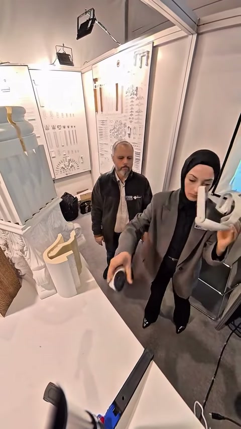 Görevli, dekoratif ürünleri ve sanal sunum ekipmanını birlikte gösteriyor.