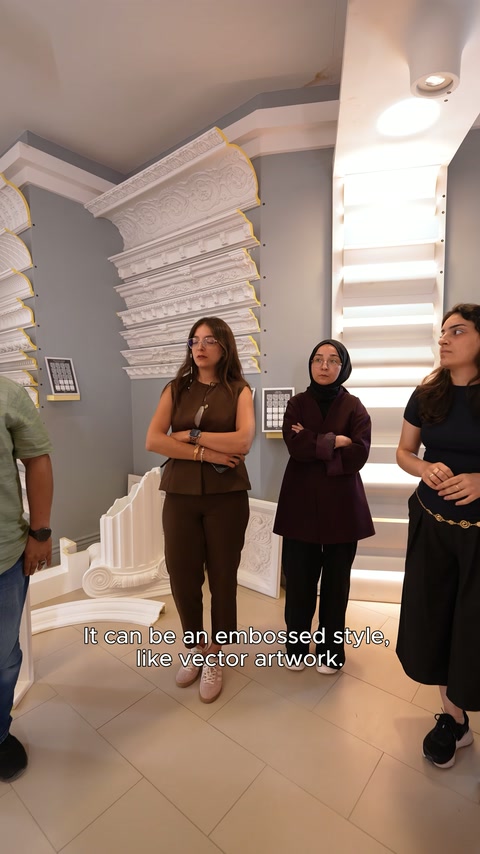 Dekoratif duvar çıtaları ve profilleri, ziyaretçilerin arkasında sergileniyor.