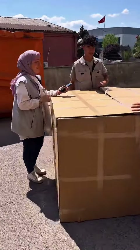 Atölye bahçesinde çalışanlar kapalı sevkiyat sandığının çevresinde bekliyor