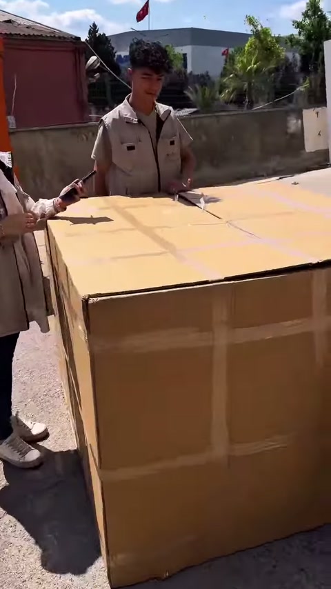 Çalışanlar karton ambalaj üzerindeki bağları çözmeye hazırlanıyor