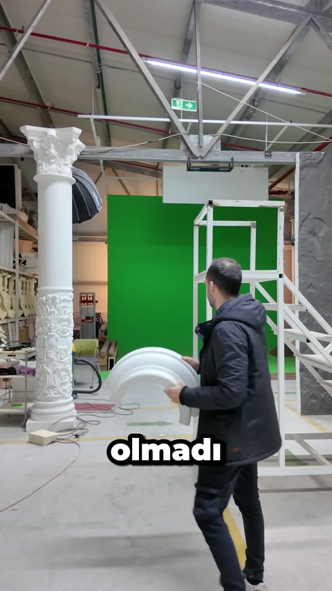 Usta dekoratif profili elinde tutarak metal iskeleye doğru dönüyor
