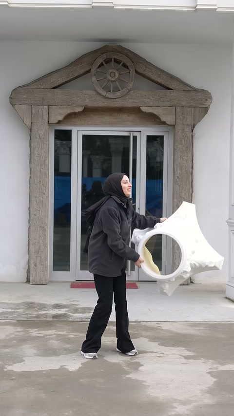 Dış mekânda büyük beyaz sütun başlığı yatay biçimde tutuluyor