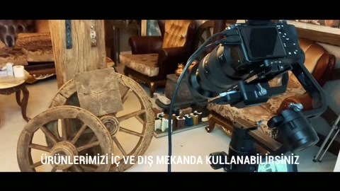 Atölyede kamera arkasında dekoratif teker ve kiriş düzeni yer alıyor.