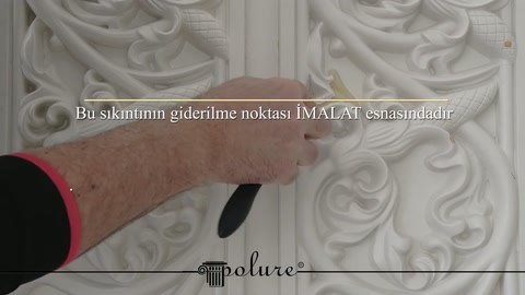 El, motifli panelde kaplama ve desen geçişlerini yakından inceliyor