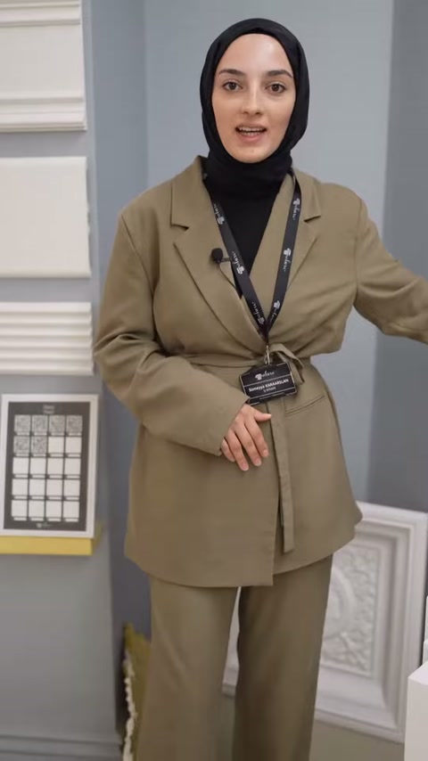 Sunucu beyaz duvar çıtaları önünde dekorasyon seçeneklerini anlatıyor.