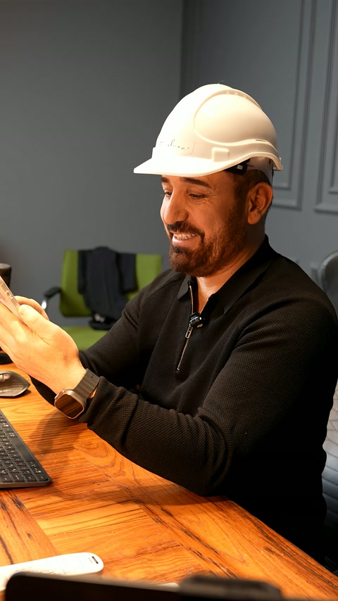Baretli uzman, el hareketleriyle dekoratif cephe fikrini açıklıyor.