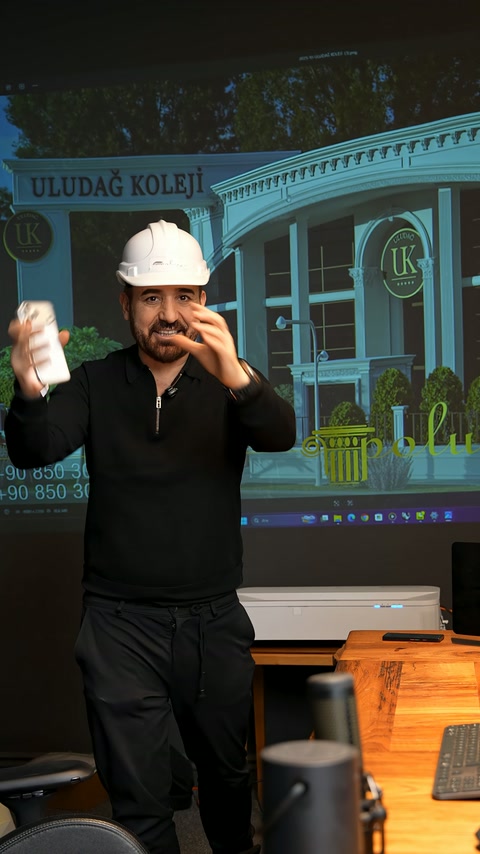 Sunucu, ekrandaki kemerli cephe tasarımını işaret ederek konuşuyor.