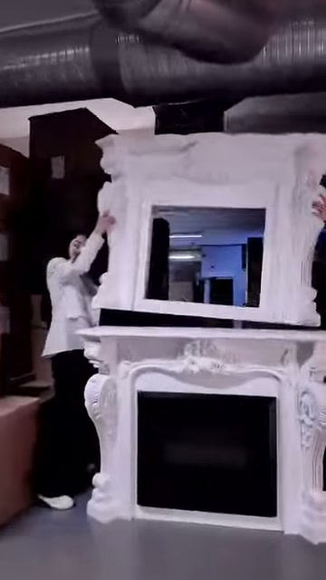 Sunucu depoda kabartmalı beyaz şömine çerçevesinin üst bölümünü tanıtıyor