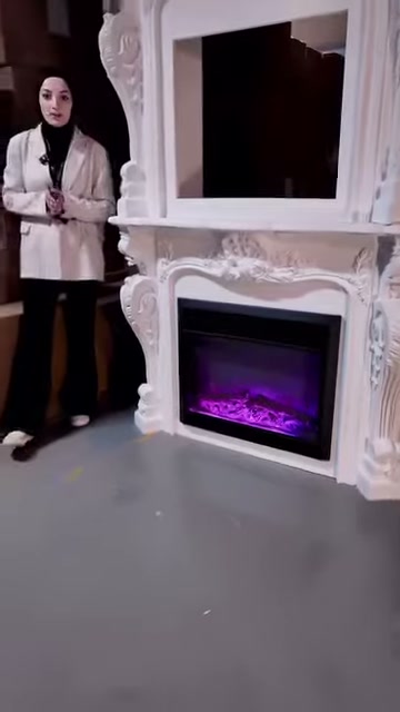 Dekoratif şöminenin mor aydınlatmalı haznesi ve boş üst alanı görülüyor