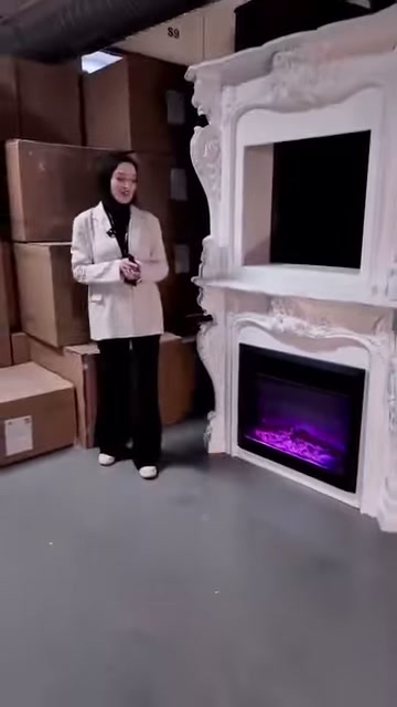 Beyaz dekoratif şömine, mor hazne ışığıyla birlikte tam boy sergileniyor