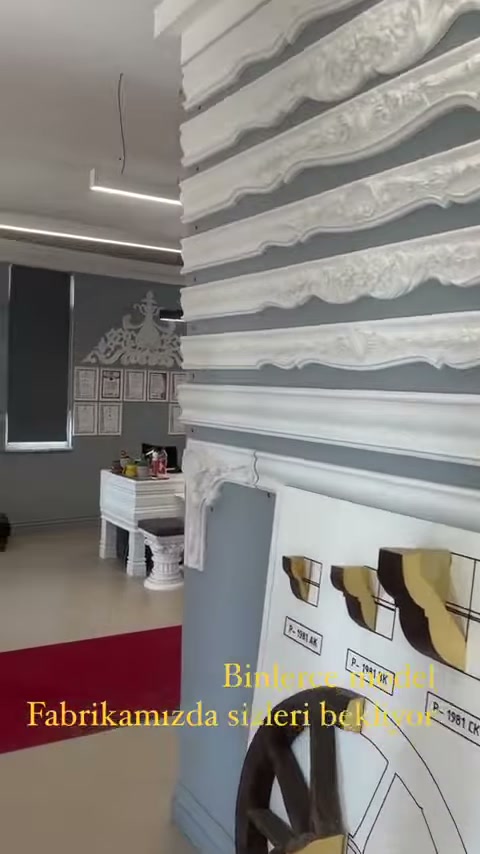 Kıvrımlı bordür modelleri gri duvarda yatay biçimde sergileniyor