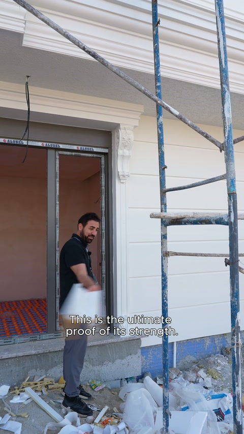 Sunucu, geniş beyaz söve parçasını pencere açıklığında sergiliyor.