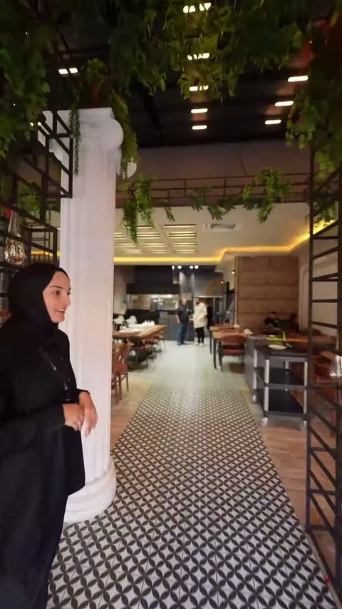 Restoran salonunun girişinde beyaz yivli sütun ve İyon başlık seçiliyor.
