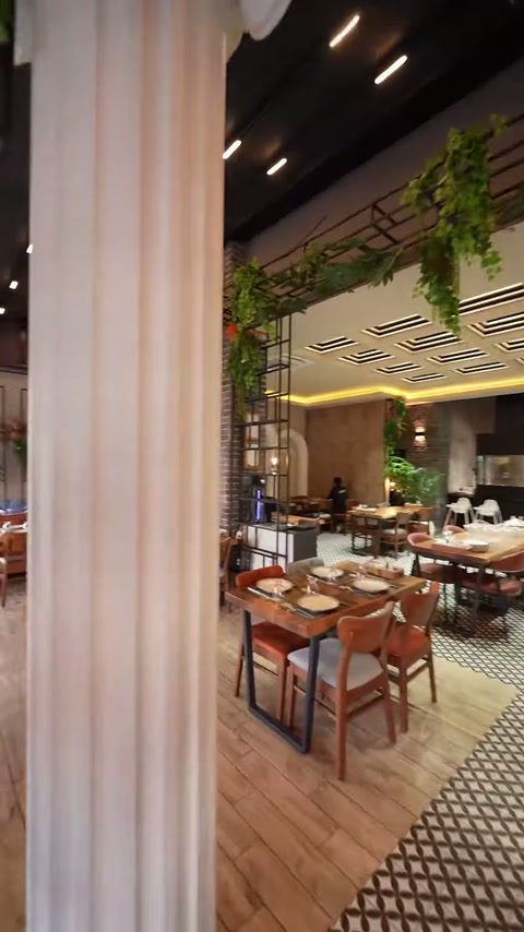 Beyaz sütun gövdesindeki dikey yivler restoran içinde yakından gösteriliyor.