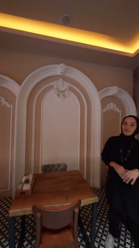 Üçlü kemer dekorasyonu, merkezdeki kabartmalı taç motifiyle sergileniyor.
