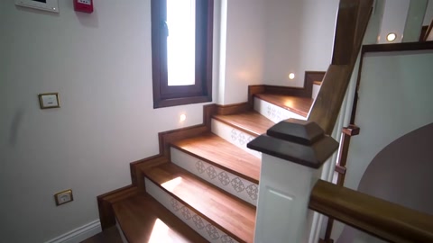 Merdiven boşluğunda basamak aydınlatmaları ve duvar bordürleri görülüyor