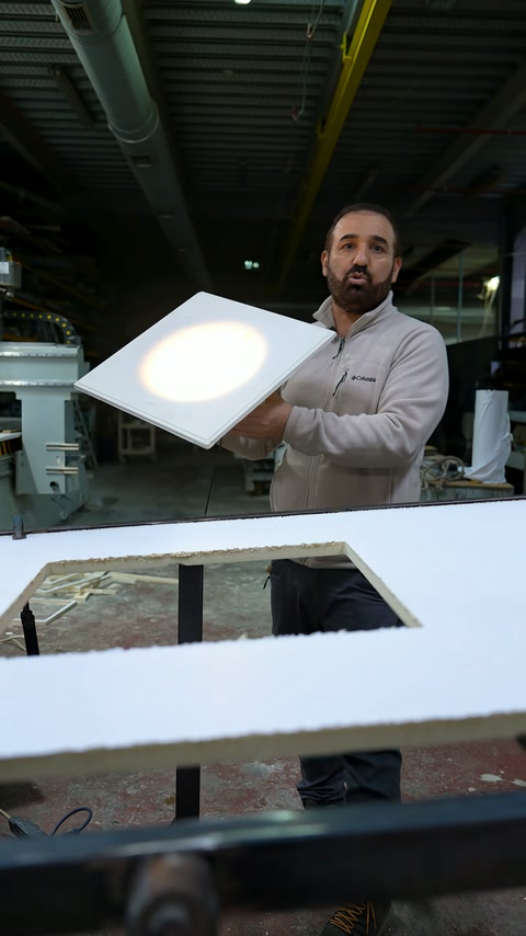 Usta, çalışan armatürü iki eliyle eğik konumda inceliyor.