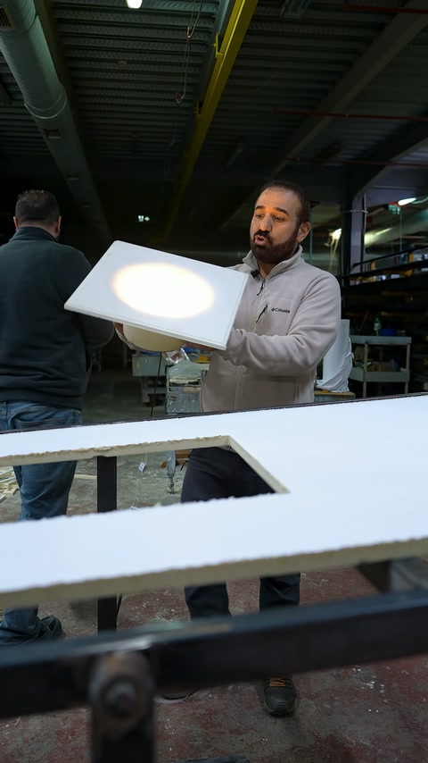 Atölyede kaldırılan kare panelin parlak merkezi ve kalın kenarı görülüyor.