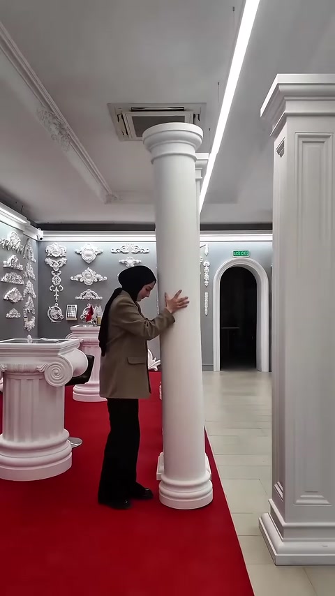 İnce yuvarlak sütunun sade gövdesi ve kademeli kaidesi görülüyor
