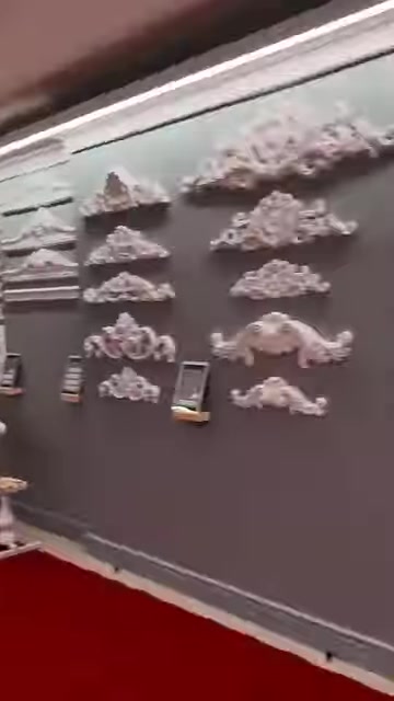 Farklı desenlerde küçük dekoratif duvar süsleri panel üzerinde sıralanıyor