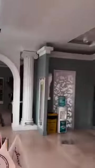 Dekoratif sütunlarla çevrelenmiş kemerli geçiş showroom içinde sergileniyor