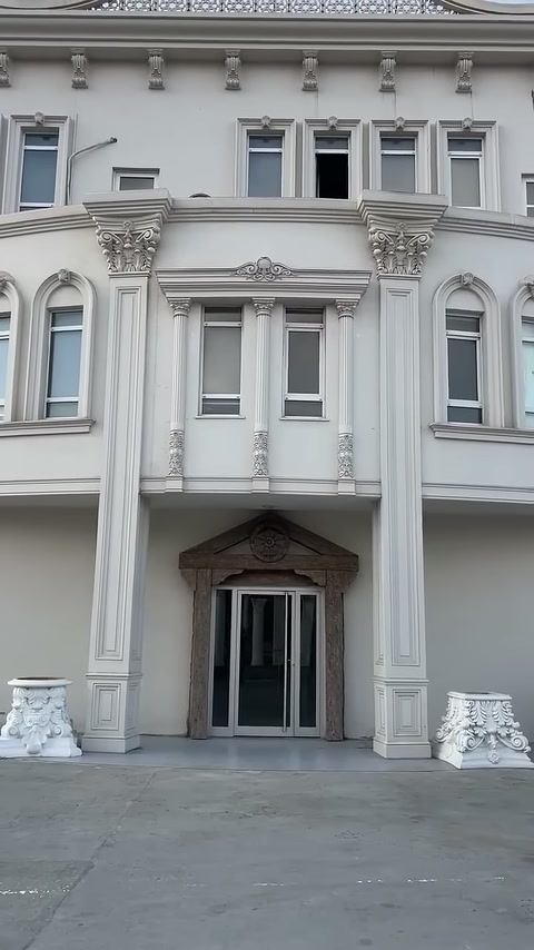 Geniş cephede yüksek pilasterler, kemerli pencereler ve süslü başlıklar sergileniyor